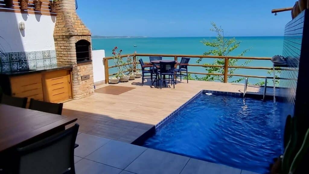 Aluguel de temporada (A casa formosa) em Baía Formosa. Essa é a área da varanda onde há uma piscina do lado direito e uma pia e churrasqueira na parede do lado esquerdo. Ao fundo há uma mesa e do outro lado há outra mesa, de frente para a visão do mar.