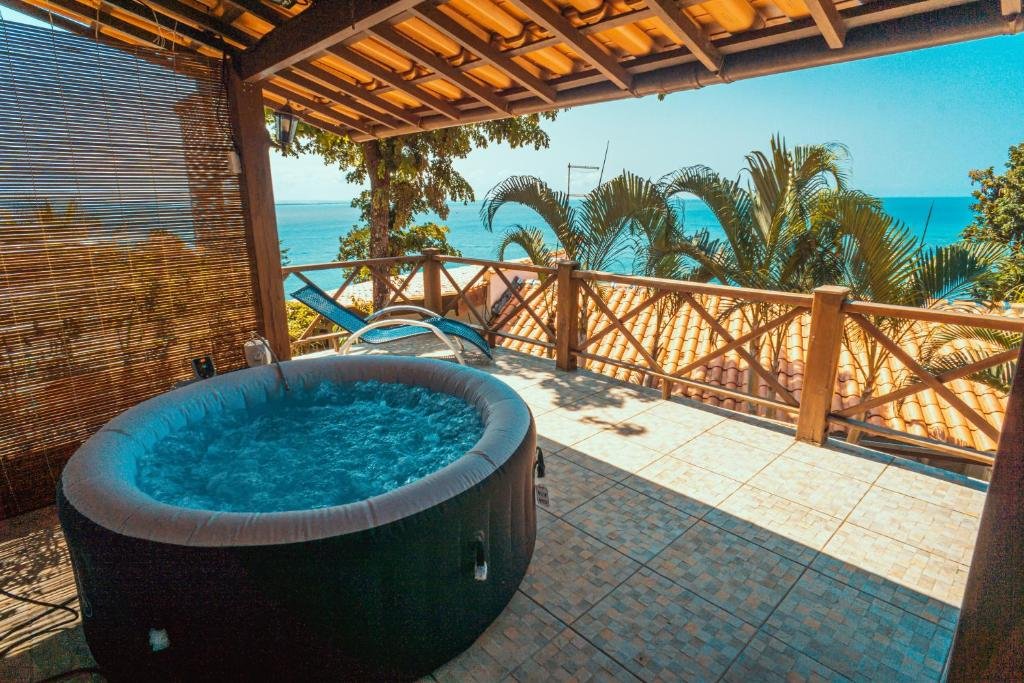 Varanda da Altavista residence. Uma banheira de hidromassagem e uma cadeira de tomar sol. Do lado direito a vista do mar.