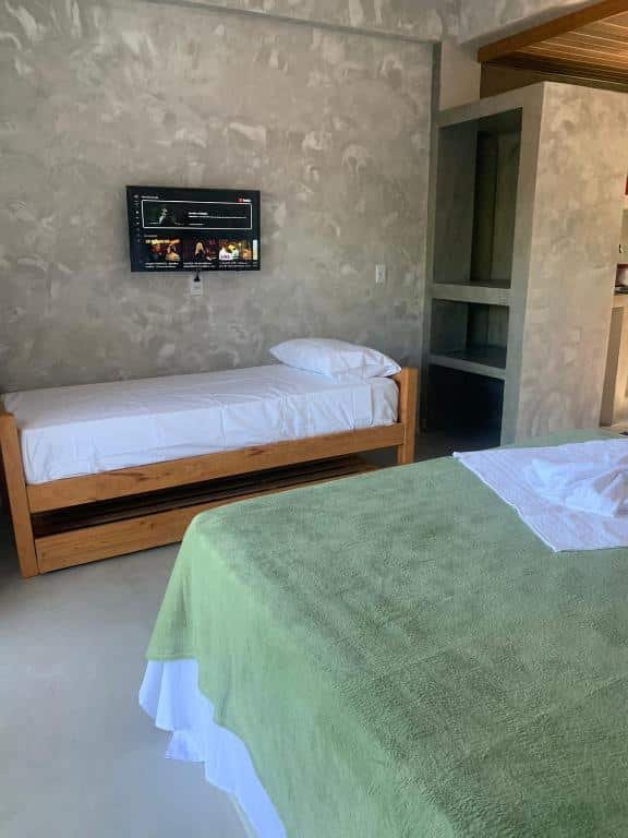 Quarto do Apartamentos de Juan. Uma cama de casal no fundo uma cama de solteiro. Em cima uma televisão e atrás um armário aberto. Foto para ilustrar post sobre airbnb em Morro de São Paulo.