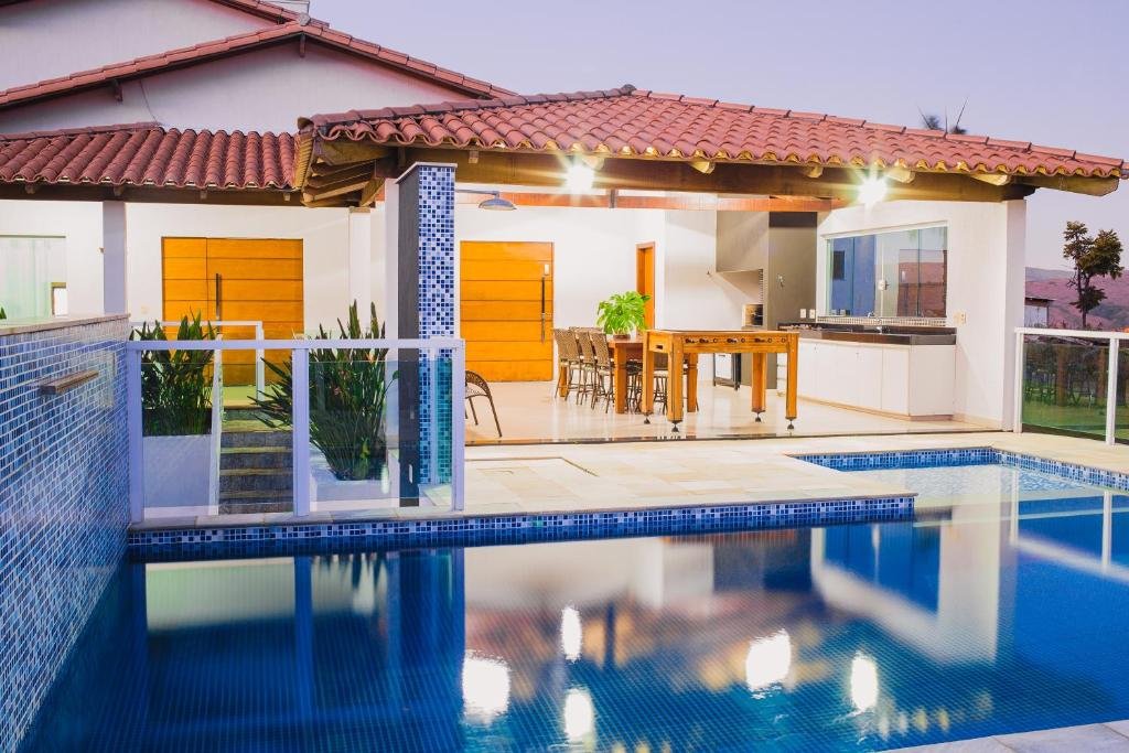 Piscina da Casa Grande em Escarpas do Lago com Linda Vista, local amplo, cercado pelas montanhas, com uma varanda com mesa de bilhar, espaço gourmet, de frente para a piscina