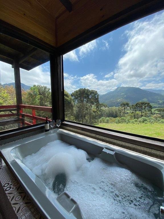 vista da natureza a partir da banheira cheia com espuma nos Chalés incríveis com banheira de hidromassagem e vista encantadora com estrutura da madeira