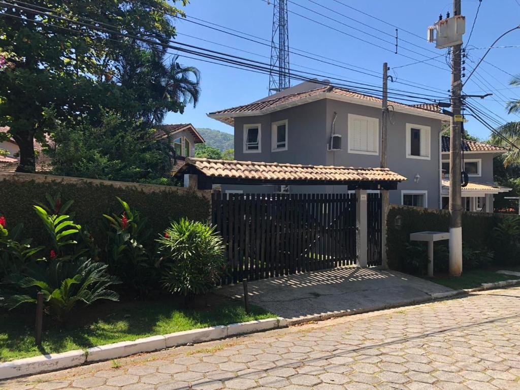 Vista da frente do Lar Doce Lar Toque Toque Grande durante o dia, com arquitetura grande, com garagem e jardim.
