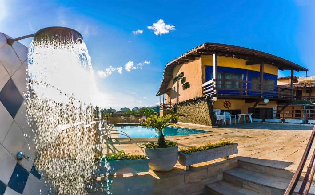 Entrada do Hotel Pousada do Sol, uma piscina ampla, um deck grande e a pousada ao lado