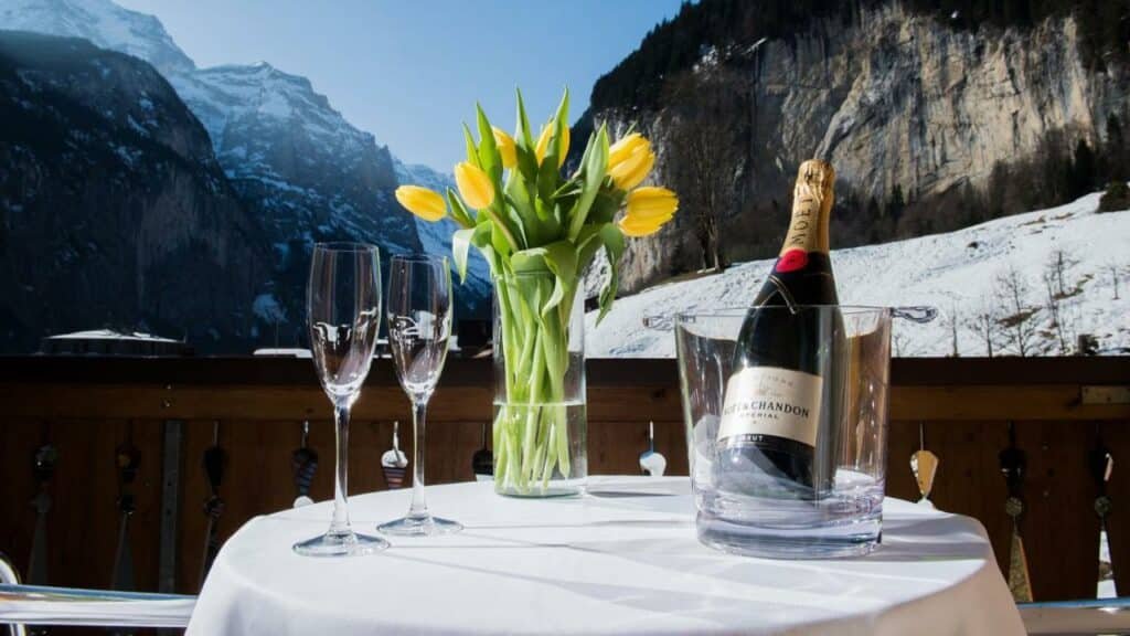 Mesa do Hotel Silberhorn durante o dia com um balde de champanhe e duas taças em cima da mesa.