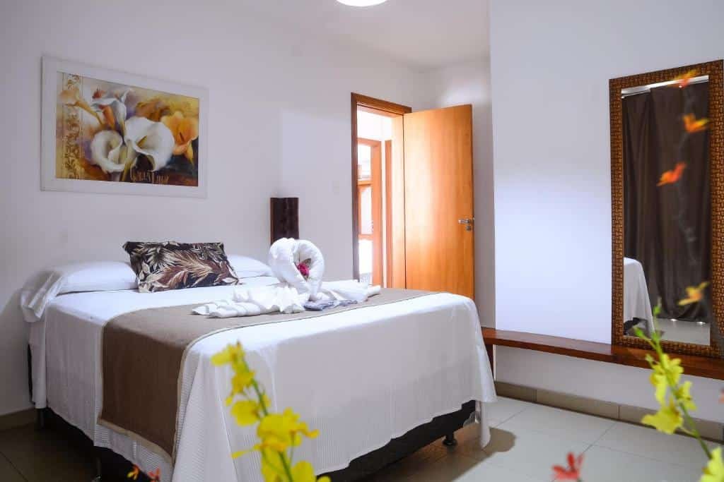 Quarto do Para Vos y Porque Si. Uma cama de casal do lado esquerdo com a porta do quarto. Do lado dirito um espelho.