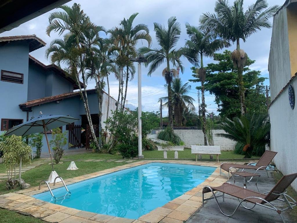 Casa agradável com piscina, uma jardim amplo com espreguiçadeiras, árvores e uma piscina