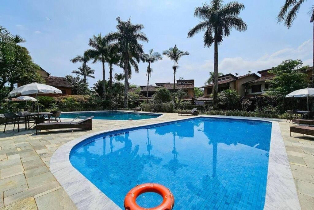 Área de lazer da Casa em Condomínio Pé na Areia na Praia do Engenho durante o dia com piscina do lado direito da imagem e do lado esquerdo outra piscina.