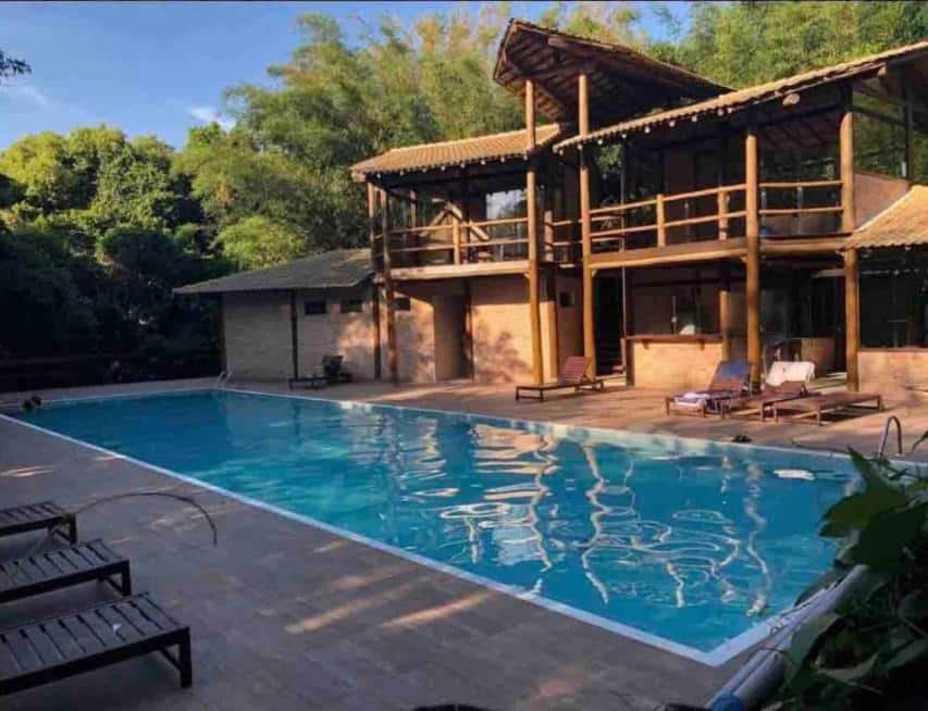 Piscina ao ar livre da Casa Pé na Areia durante o dia com piscina a frente e ao fundo a estadia.