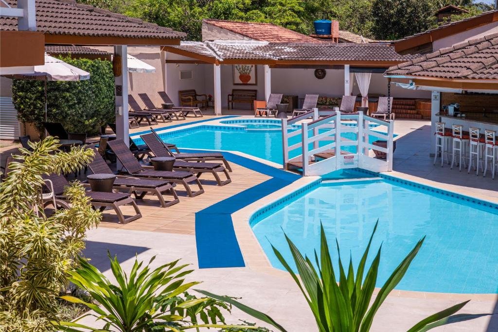 Vista da piscina do Ciribaí Praia Hotel durante o dia com cadeiras em volta.
Representa pousadas na praia de Calhetas.
