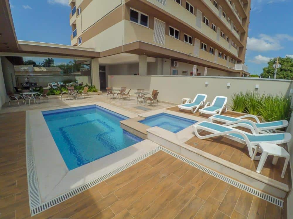 Piscina para adultos e uma para crianças em formato quadrado. Ao redor existem diversas mesas e cadeiras. Foto para ilustrar post sobre hotéis em Campo Grande.