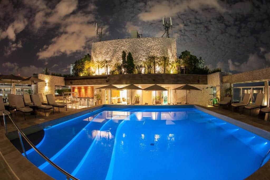 Piscina do Parque Balneário Santos by Atlantica Hotels de noite com iluminação no deck ao redor onde estão espreguiçadeiras e guarda-sóis
