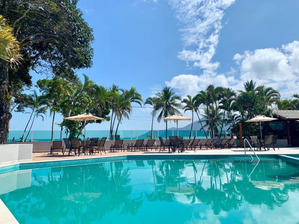 Vista da piscina do Porto Paúba durante o dia, com cadeiras e mesas do lado esquerdo.