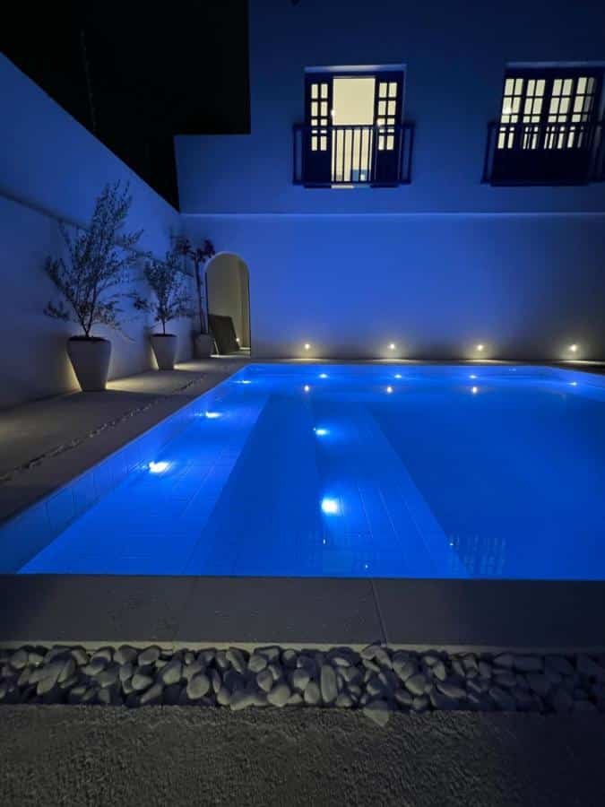 Piscina ampla da Pousada Vila Santô inteira iluminada de noite