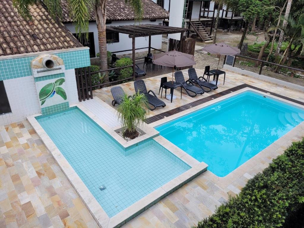 Vista de cima da piscina da Pousada Tartarugas de Paúba com cadeiras perto da piscina.