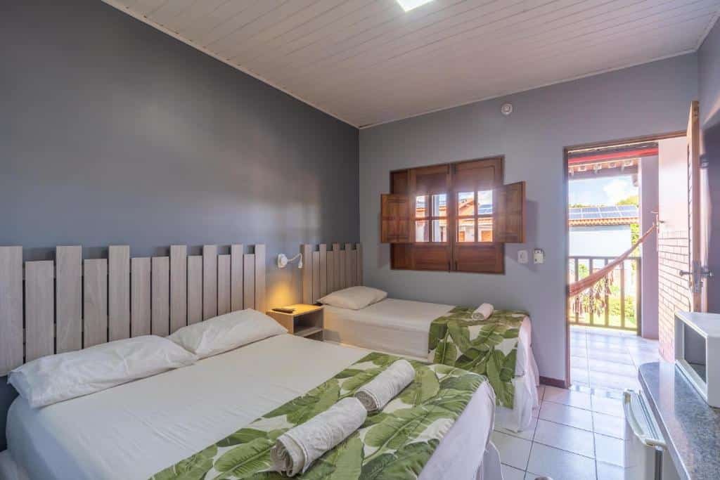 Quarto da Pousada Blue Viking, de 15 m², com uma cama de casal, uma de solteiro, e uma varanda com rede