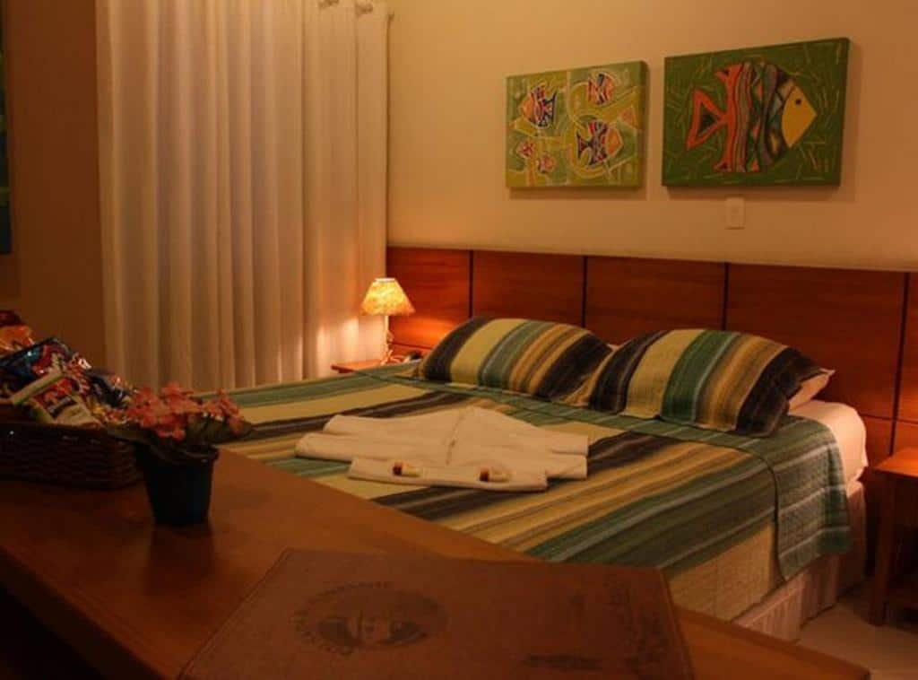 Quarto da Pousada do Almirante com cama de casal, duas cômodas ao lado e uma cômoda a frente da cama.