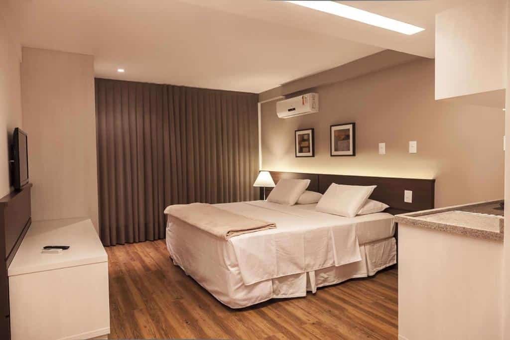 Quarto com cama ampla e TV no Atmosfera Hotel.