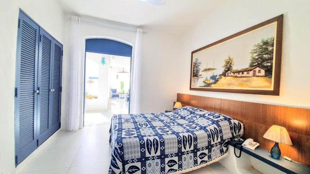 Quarto do Brisa do Mar Barê Praia Hotel com cama de casal, luminária do lado direito e em frente a cama guarda roupa.