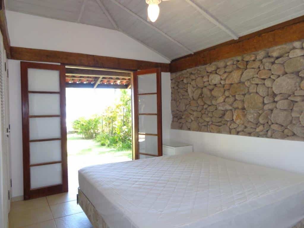 Vista do quarto Casa pé na areia de Revista com cama e varanda.