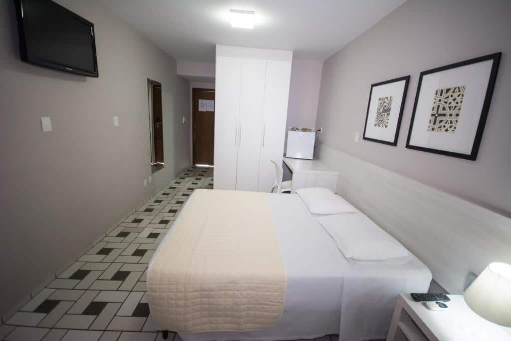Quarto do Hotel São Domingos com cama e TV.