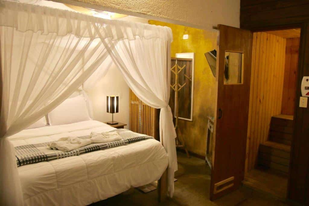 Quarto da Ilha de Toque Toque Boutique Hotel & Spa com cama de casal, duas cômodas ao lado da cama.