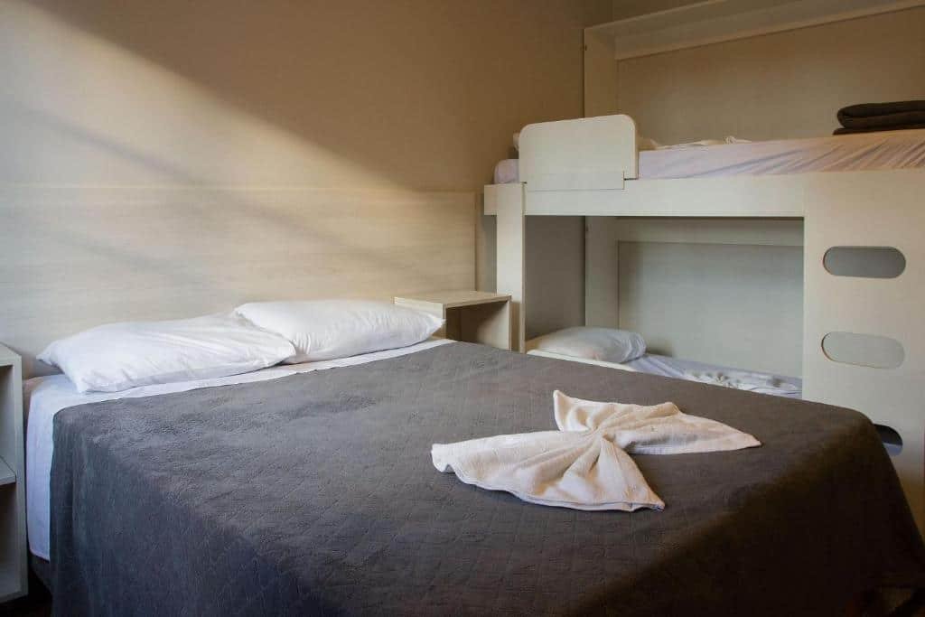 Quarto em Incrível apartamento no Centro de Gramado , uma cama de casal e uma beliche, para representar airbnb em Gramado