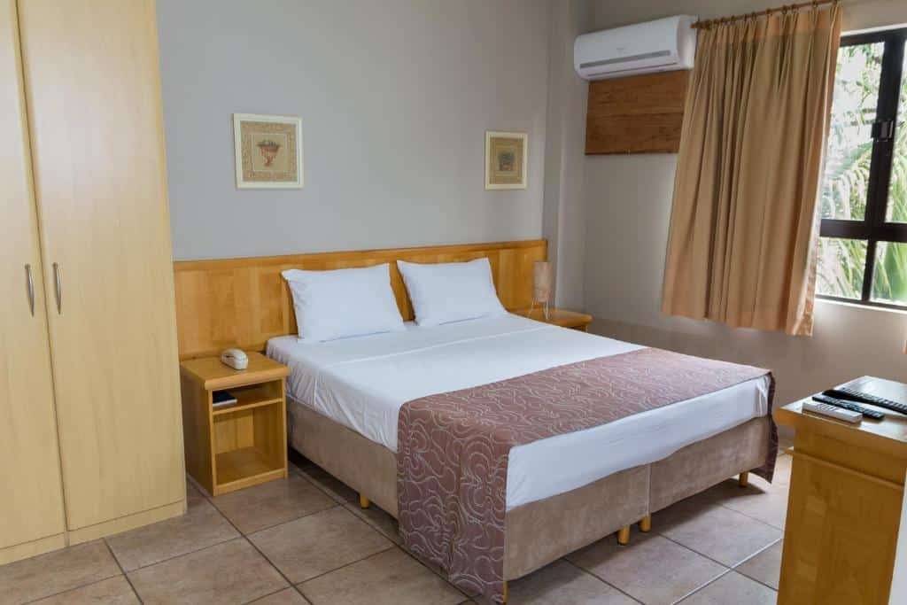 Quarto da Maria Quitéria Hotel & Flat com cama, guarda-roupa e cômoda.