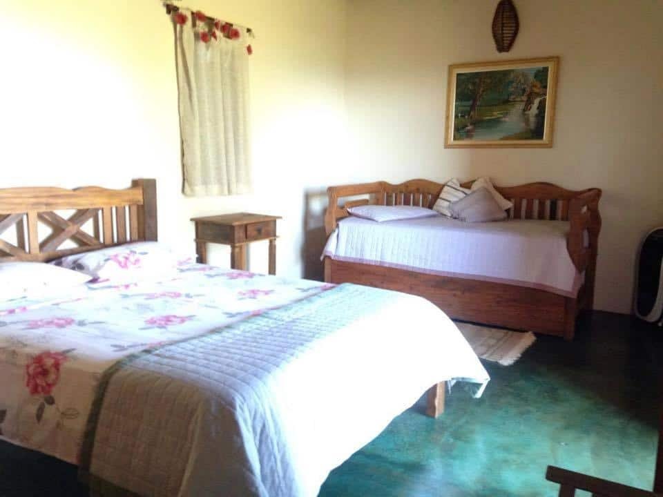 Quarto da Pousada Encantos do Cerrado com cama e sofá cama.