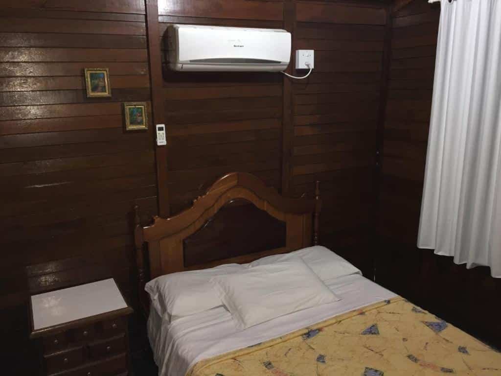 suíte da Pousada Jardim da Chapada com uma cama de casal e um ar-condicionado