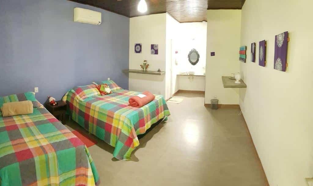 suíte da Pousada Luz do Jamacá na Chapada dos Guimarães com uma cama de casal e uma cama de solteiro