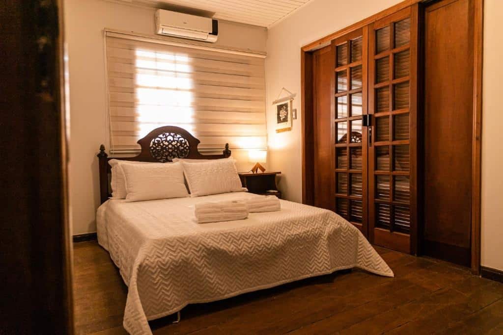 quarto da Pousada Paraíso dos Guimarães com uma cama de casal e um ar-condicionado