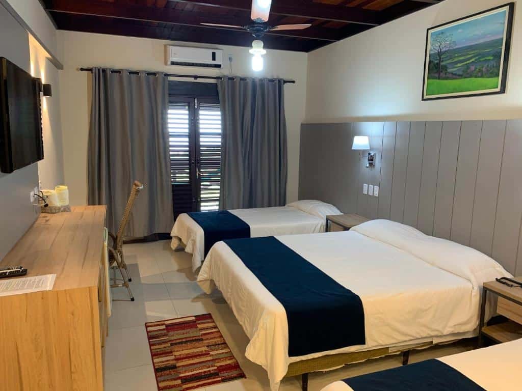 quarto da Pousada Penhasco com uma cama de casal e duas camas de solteiro