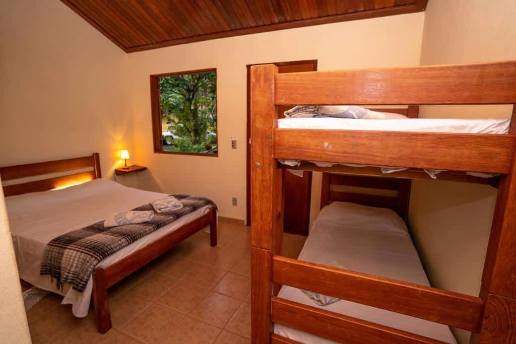 Quarto com cama de casal e belich na Pousada Rosa dos Ventos.