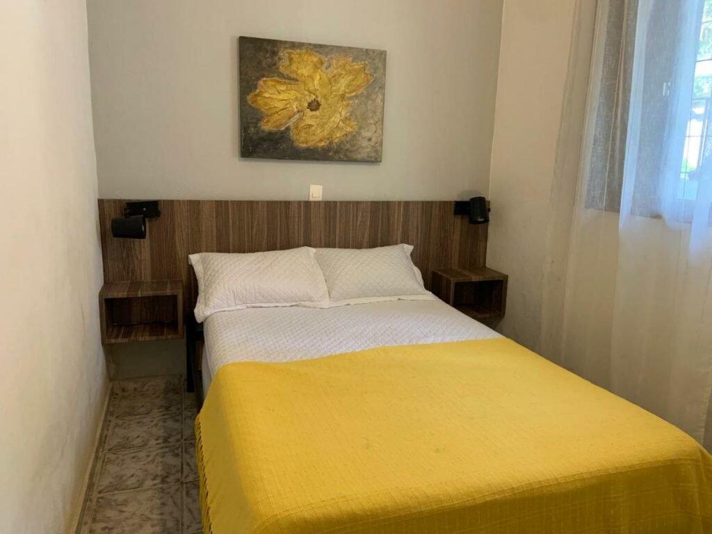 Quarto do Sean bora praia com cama de casal no centro do quarto. Representa airbnb na praia da Juréia.