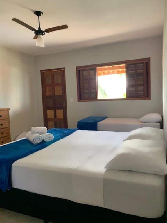 Quarto da Pousada Xu Beleza em Delfinópolis com cama de casal e uma de solteiro.