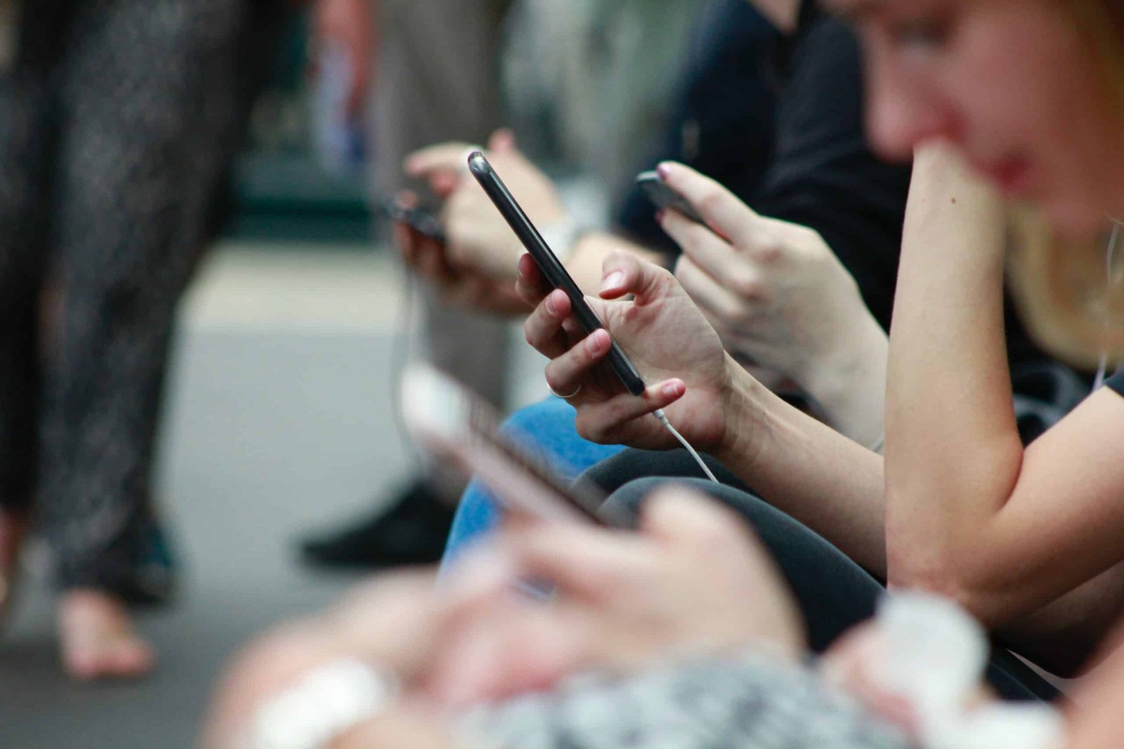 variás pessoas desfocadas mexendo em seus celulares para representar o post sobre chip de celular em Oslo.