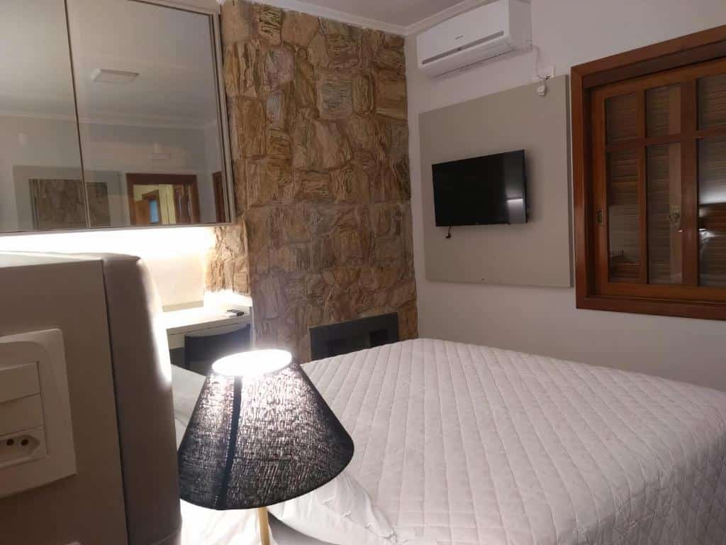 quarto do Locanda Montecielo por outro ângulo, onde se vê a TV na parede em frente à cama