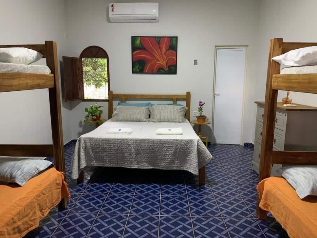 quarto da Pousada Beija-Flor com uma cama de casal e duas beliches