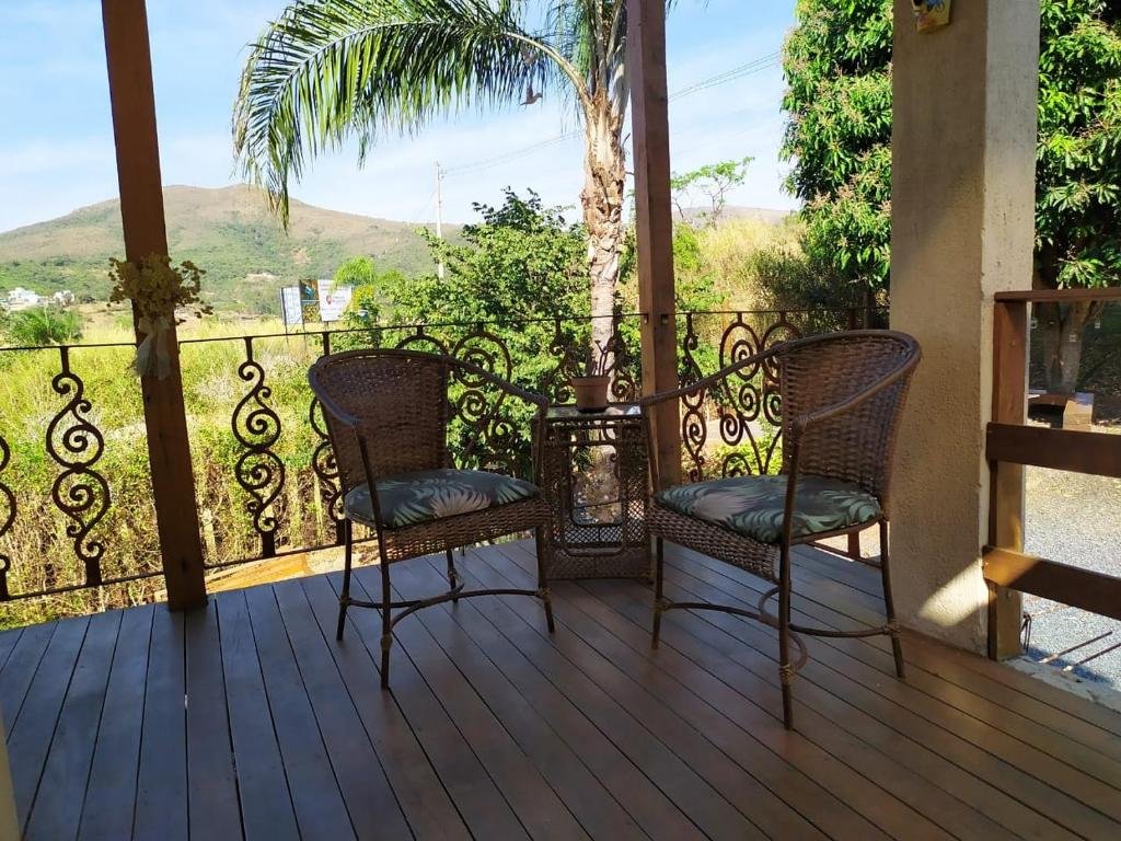 Varanda do Terrazzo Suites, com duas cadeiras e muita natureza e vista para as montanhas